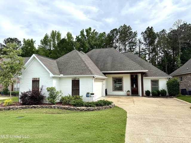 view of front facade featuring a garage, driveway, a front lawn, brick siding, and central AC unit