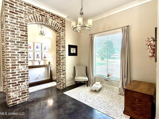 living area with concrete floors, a chandelier, baseboards, ornamental molding, and arched walkways