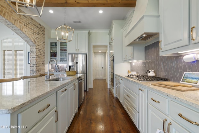 508 Forest Glen Ln, Brandon, MS 39047 - kitchen with premium range hood, white cabinetry, stainless steel appliances, backsplash, and a chandelier