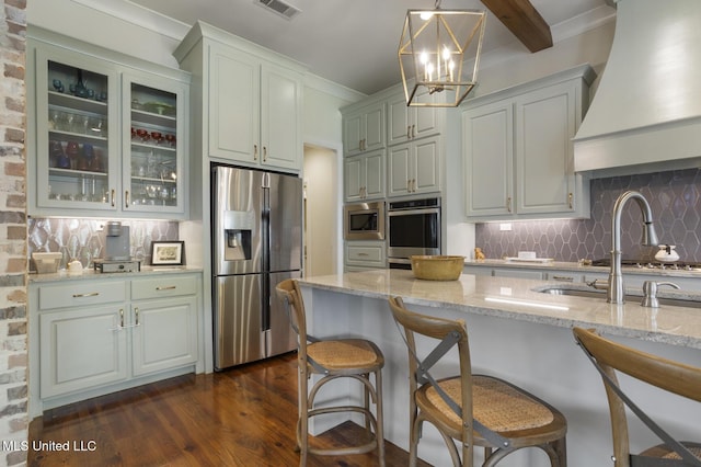508 Forest Glen Ln, Brandon, MS 39047 - kitchen featuring appliances with stainless steel finishes, custom range hood, dark wood-style flooring, light stone countertops, and glass insert cabinets