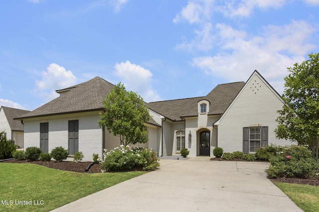 508 Forest Glen Ln, Brandon, MS 39047 - french country inspired facade with a front lawn, concrete driveway, a shingled roof, and brick siding