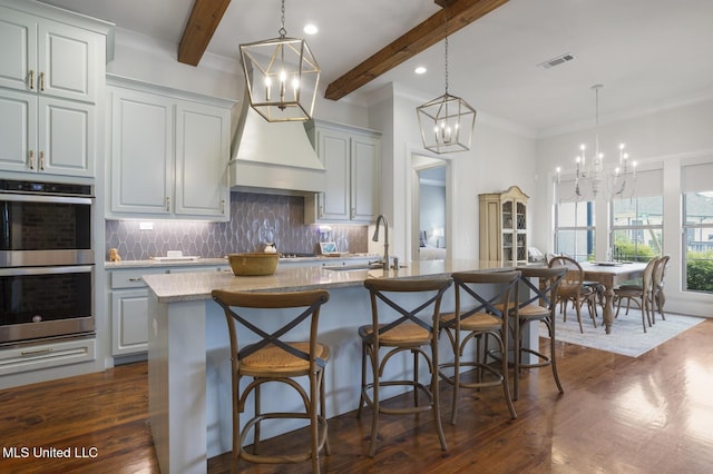 508 Forest Glen Ln, Brandon, MS 39047 - kitchen featuring double oven, a chandelier, beam ceiling, dark wood-style floors, and decorative backsplash