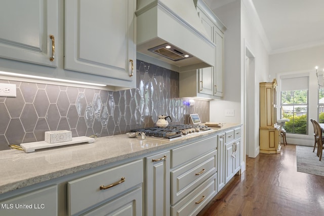 508 Forest Glen Ln, Brandon, MS 39047 - kitchen with custom exhaust hood, ornamental molding, dark wood-style floors, stainless steel gas stovetop, and light stone counters