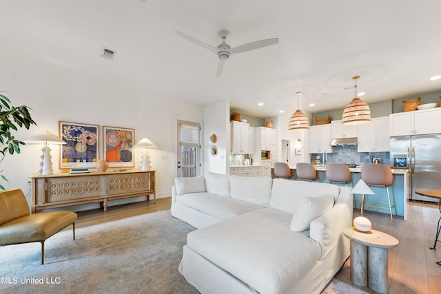 218 Front St, Pass Christian, MS 39571 - living area with wood finished floors, ceiling fan, and recessed lighting