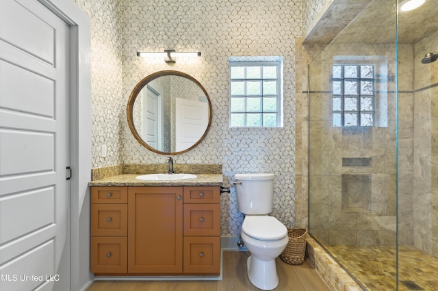 218 Front St, Pass Christian, MS 39571 - bathroom with toilet, tiled shower, vanity, and wood finished floors