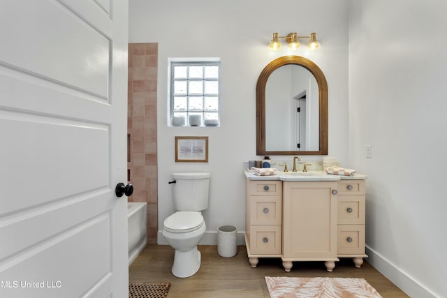 218 Front St, Pass Christian, MS 39571 - full bath featuring baseboards, toilet, vanity, and wood finished floors