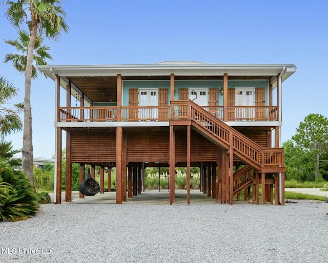 218 Front St, Pass Christian, MS 39571 - coastal inspired home featuring a carport, stairway, and gravel driveway