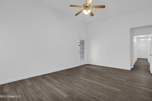 unfurnished room featuring ceiling fan, baseboards, and dark wood-type flooring