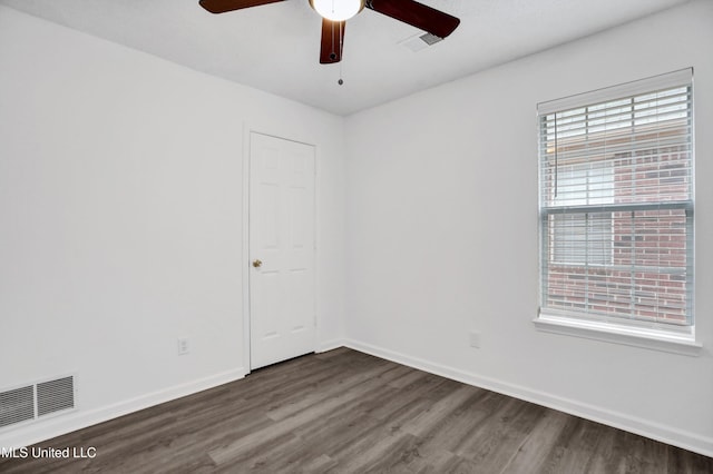 spare room featuring a ceiling fan, wood finished floors, visible vents, and baseboards