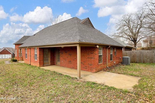 back of house with a yard, brick siding, fence, and a shingled roof