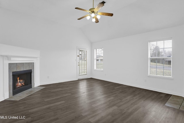 unfurnished living room with plenty of natural light, dark wood-style flooring, and a tile fireplace