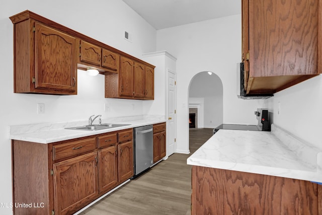 kitchen with light countertops, stainless steel dishwasher, range with electric cooktop, and a sink