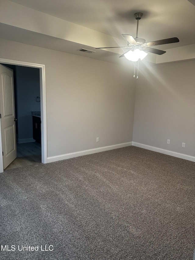 spare room featuring carpet floors, baseboards, visible vents, and a ceiling fan