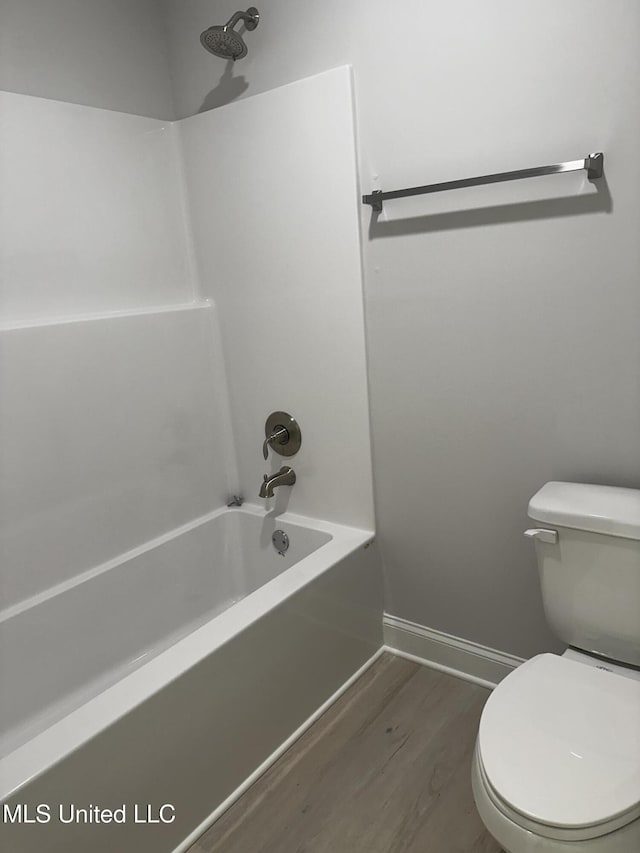 bathroom with shower / bath combination, wood finished floors, toilet, and baseboards