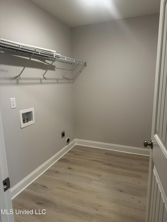 laundry room featuring laundry area, washer hookup, wood finished floors, and baseboards