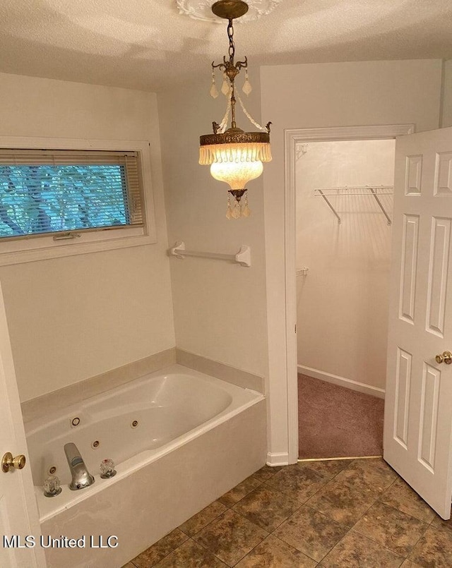 bathroom featuring a tub to relax in and a textured ceiling