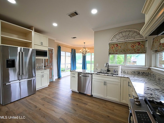 6936 Aulena Pl, Diamondhead, MS 39525 - kitchen with appliances with stainless steel finishes, ornamental molding, a chandelier, recessed lighting, and light stone counters