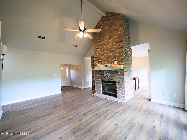 6936 Aulena Pl, Diamondhead, MS 39525 - unfurnished living room with ceiling fan, high vaulted ceiling, wood finished floors, beam ceiling, and a brick fireplace