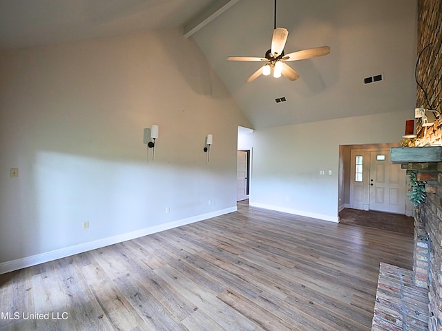 6936 Aulena Pl, Diamondhead, MS 39525 - unfurnished living room featuring high vaulted ceiling, beamed ceiling, a ceiling fan, wood finished floors, and a fireplace with raised hearth