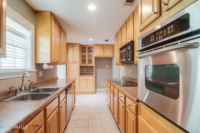 1025 Shipp St, Waveland, MS 39576 - kitchen featuring stainless steel appliances, a sink, light tile patterned floors, recessed lighting, and glass insert cabinets