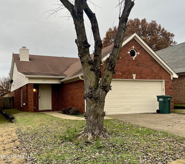 7827 S Chesterfield Dr, Southaven, MS 38671 - view of front of house featuring brick siding, driveway, an attached garage, and a chimney