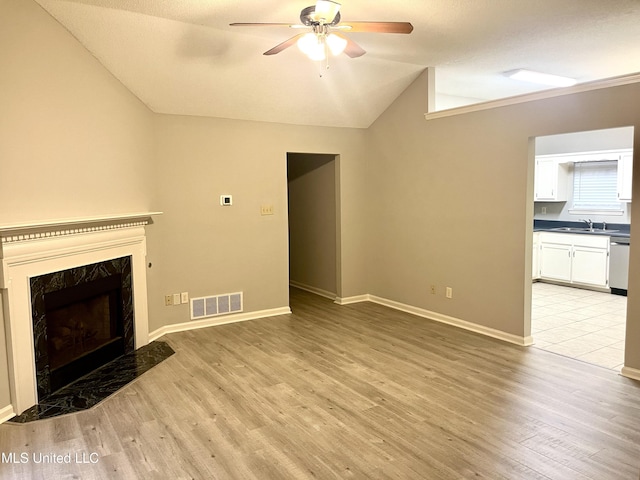 7827 S Chesterfield Dr, Southaven, MS 38671 - unfurnished living room featuring lofted ceiling, a sink, a ceiling fan, light wood finished floors, and a premium fireplace
