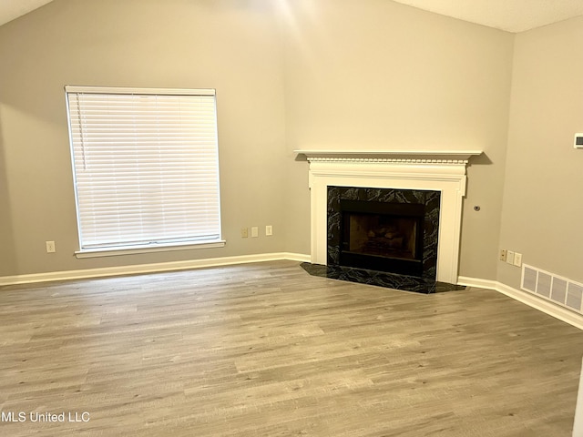 7827 S Chesterfield Dr, Southaven, MS 38671 - unfurnished living room with wood finished floors, lofted ceiling, a premium fireplace, and baseboards