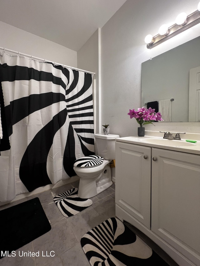 bathroom with walk in shower, vanity, toilet, and tile patterned flooring