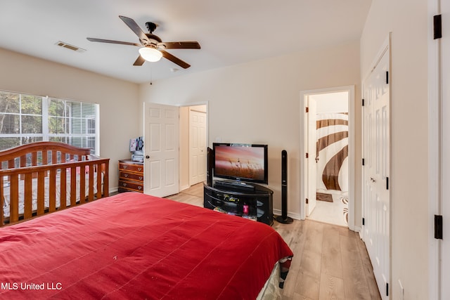 bedroom featuring ensuite bath, light hardwood / wood-style floors, and ceiling fan