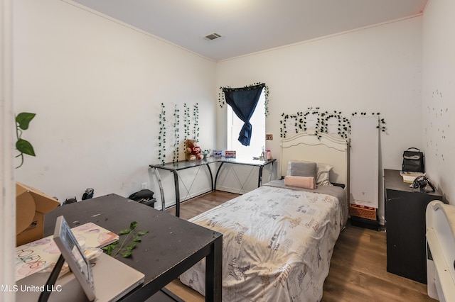 bedroom with ornamental molding and hardwood / wood-style floors