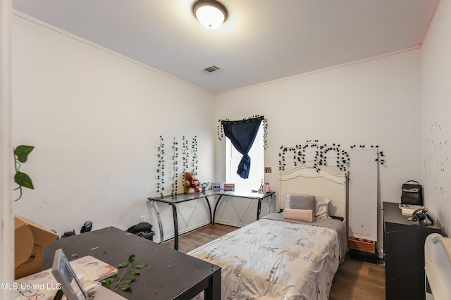 bedroom featuring crown molding and hardwood / wood-style flooring