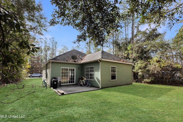 rear view of house with a patio and a lawn