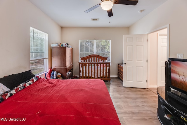 bedroom featuring ceiling fan, multiple windows, and hardwood / wood-style flooring