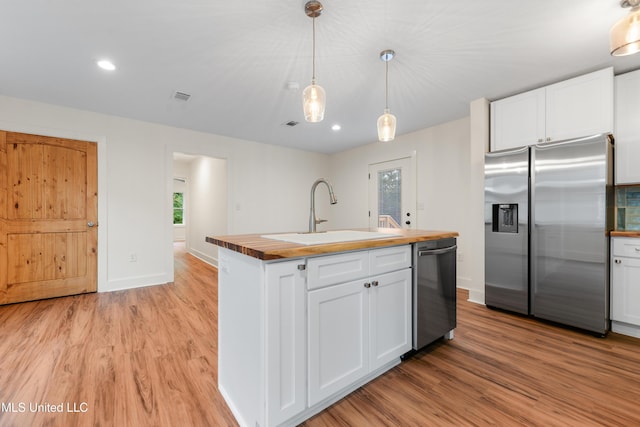 2312 6th Ave, Gulfport, MS 39501 - kitchen with stainless steel appliances, butcher block countertops, a sink, light wood finished floors, and recessed lighting