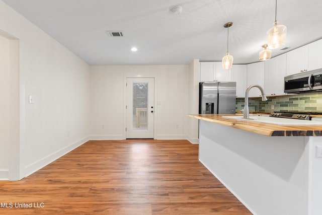 2312 6th Ave, Gulfport, MS 39501 - kitchen featuring appliances with stainless steel finishes, wood counters, backsplash, wood finished floors, and white cabinets
