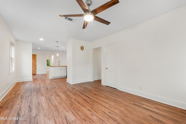 2312 6th Ave, Gulfport, MS 39501 - unfurnished living room featuring light wood finished floors, a ceiling fan, baseboards, recessed lighting, and a sink