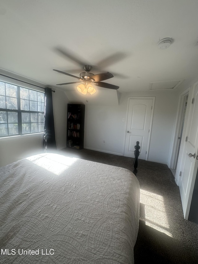 unfurnished bedroom with carpet floors, a ceiling fan, and attic access