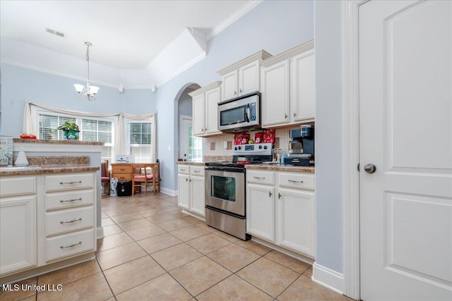 3753 Kenton Dr, Southaven, MS 38672 - kitchen with stainless steel appliances, crown molding, arched walkways, light tile patterned floors, and decorative backsplash