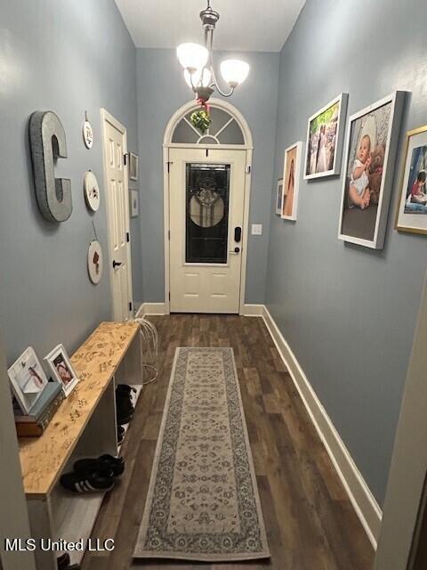 doorway featuring dark hardwood / wood-style floors and a chandelier