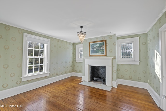 unfurnished living room with wood-type flooring, a fireplace with flush hearth, and wallpapered walls