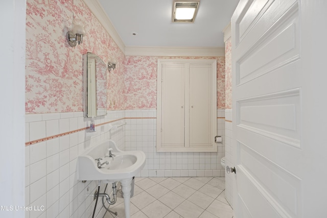 half bathroom featuring wallpapered walls, a wainscoted wall, and tile patterned floors