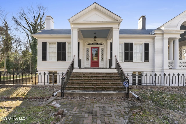 view of front of house featuring a chimney, a gate, and a fenced front yard