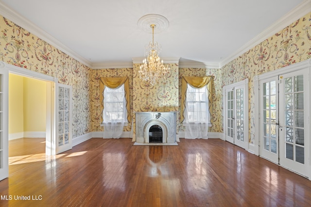 unfurnished living room featuring a wealth of natural light, wood finished floors, a fireplace, and wallpapered walls