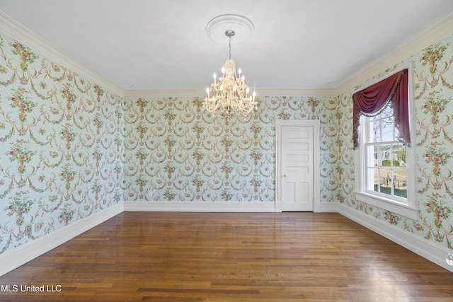 spare room featuring ornamental molding, wood finished floors, a chandelier, baseboards, and wallpapered walls