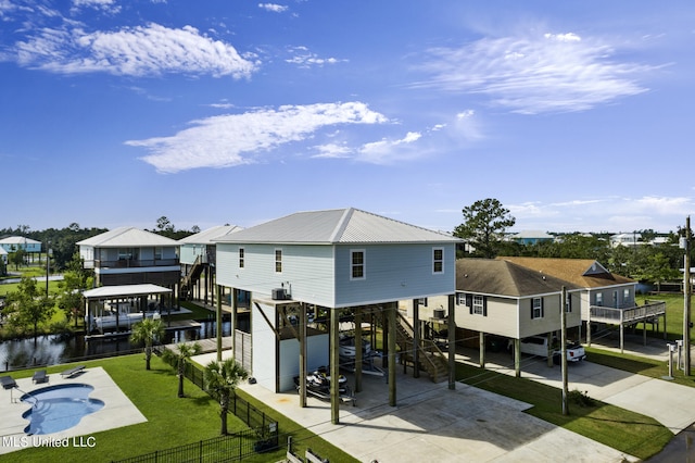 back of house with a swimming pool side deck with water view and a patio area