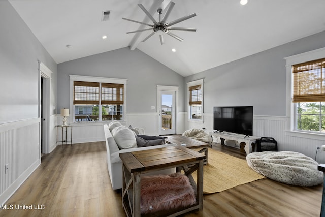 living room with hardwood / wood-style floors, vaulted ceiling with beams, and ceiling fan