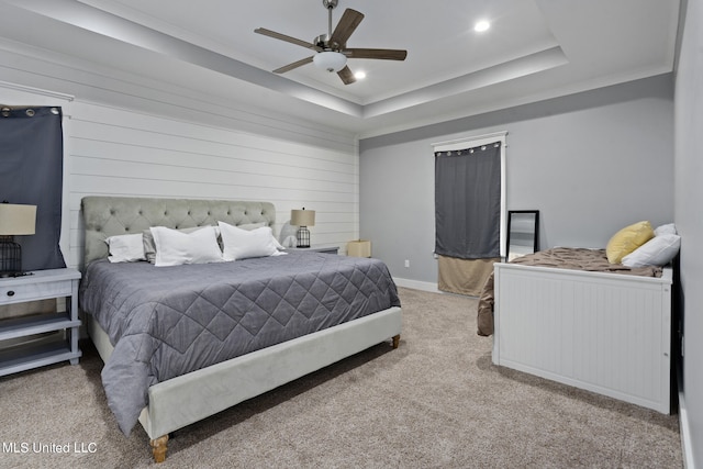 bedroom with ornamental molding, ceiling fan, light colored carpet, and a raised ceiling