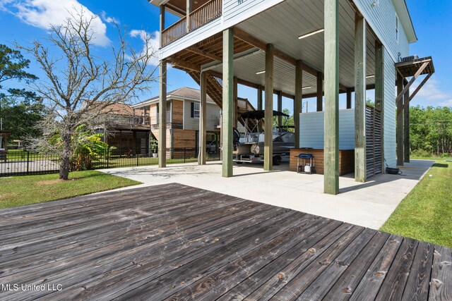 wooden terrace featuring a yard and a patio area