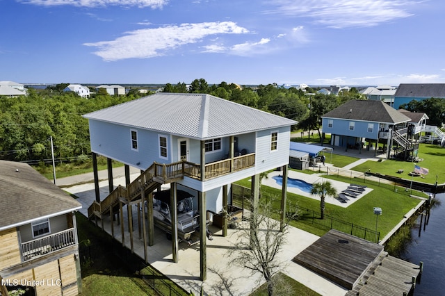 rear view of property featuring a lawn, a patio, and a fenced in pool