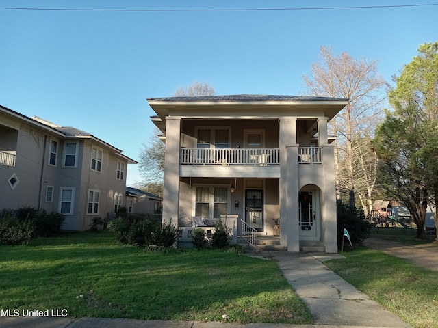 109 E Percy St, Indianola, MS 38751 - view of front of house featuring a balcony, covered porch, stucco siding, and a front lawn